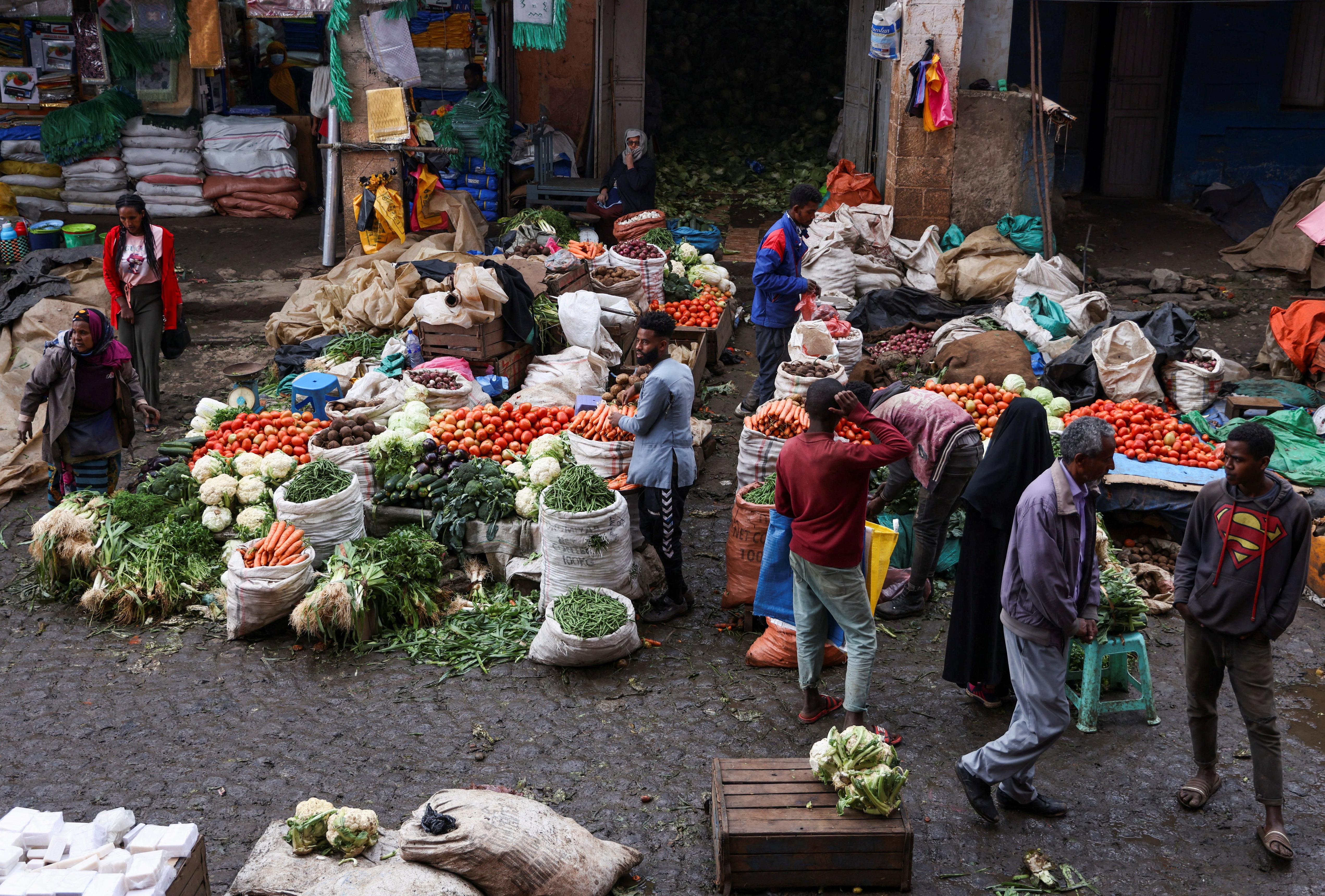 Ethiopian market vendors selling fresh vegetables as inflation rises to 15.3% amid higher food, sugar and coffee prices.